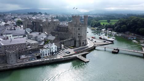 Antiguo-Castillo-De-Caernarfon-Ciudad-Portuaria-Galesa-Vista-Aérea-Medieval-Frente-Al-Mar-Punto-De-Referencia-Alejarse-Revelar