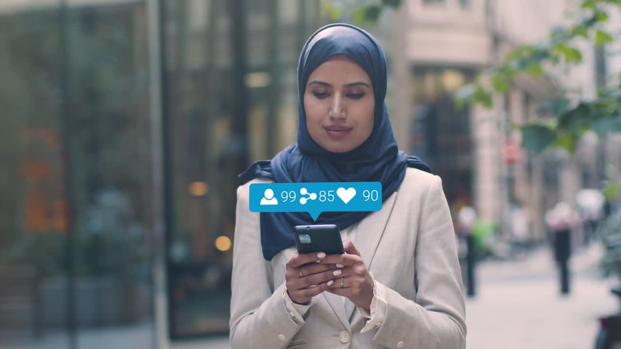 Muslim Businesswoman Standing Outside City Offices Looking At Mobile Phone With Motion Graphics Showing Multiple Networking Messaging And Social Media Notifications