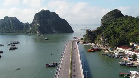 drone flyover viaduct towards halong bay with small fishing port, vietnam