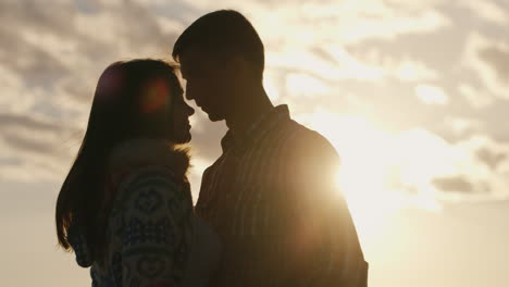 Silhouette-Eines-Jungen-Verliebten-Paares-Auf-Dem-Hintergrund-Von-Himmel-und-Sonne,-Die-Sich-Anschaun