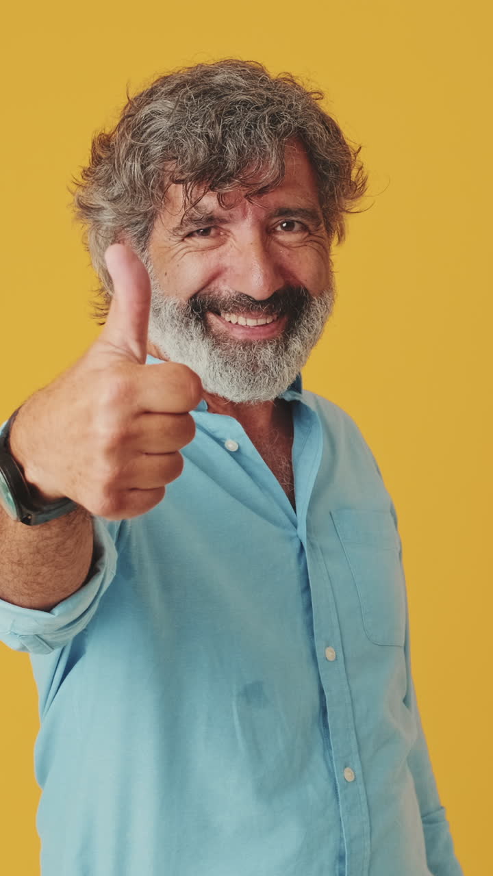 Hombre maduro señala y levanta el pulgar con una sonrisa