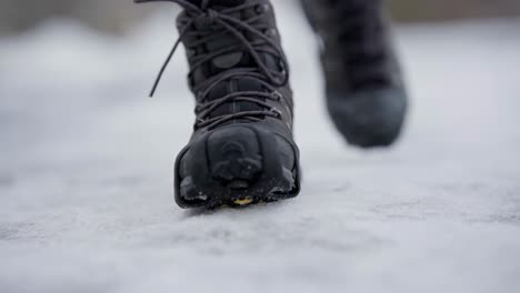 Pies-Caminando-Hacia-La-Cámara-Con-Picos-De-Hielo-En-Los-Zapatos,-Cámara-Lenta-De-Cierre-Manual