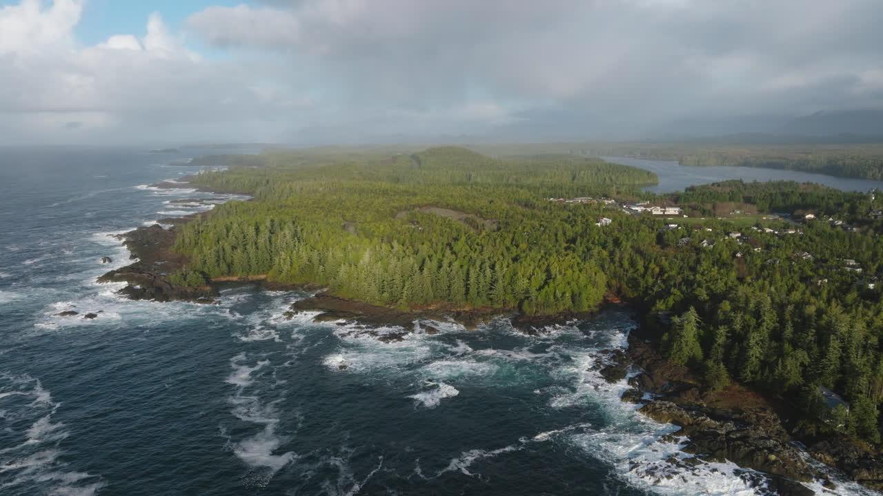 Video drone saat matahari terbenam di Ucluelet, British Columbia, Kanada, di atas samudra dan hutan.