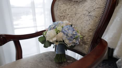 a white and blue wedding bouquet on a chair