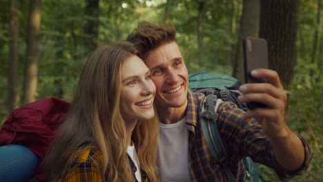 couple hiking and taking selfies in a forest