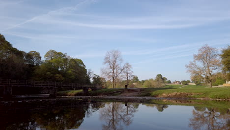 toma panorámica de las ruinas de la abadía de bolton en una hermosa mañana de verano en yorkshire, inglaterra, revelando el cruce del río