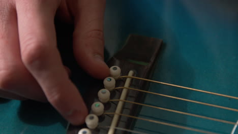 mostrando nuevas clavijas en una guitarra recién restaurada