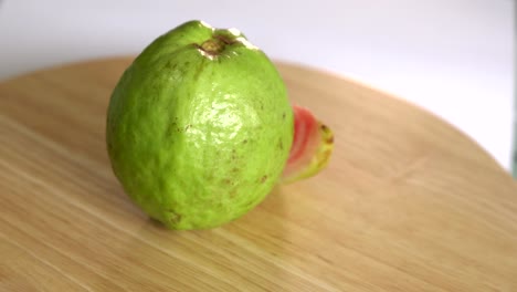 guava with slice rotates on wooden table and white background