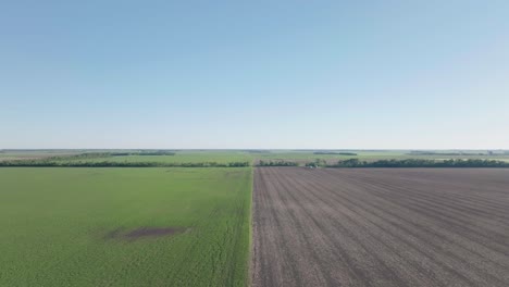 drone shot capturing long green fields and soil land during daytime in usa.