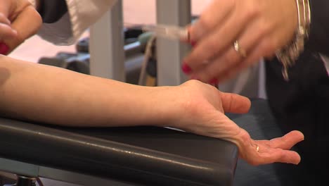 female nurse takes out transfusion needle from blood donor, closeup static