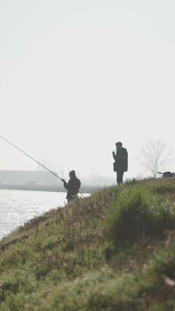 Orang-orang memancing di tepi air