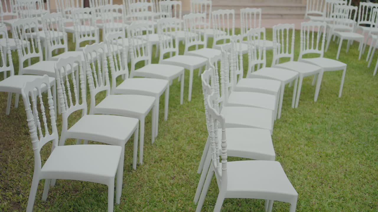 Sillas blancas elegantes dispuestas para una ceremonia al aire libre