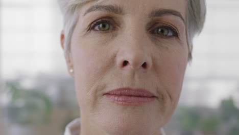 close up portrait of confident senior caucasian woman looking serious pensive at camera in plants background