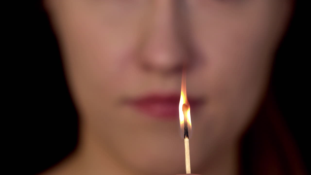 Unhappy woman staring a candlelight. Lonely lady open her mouth with lipstick blowing the fire. Angry lady with positive hope. Tender woman watch candle