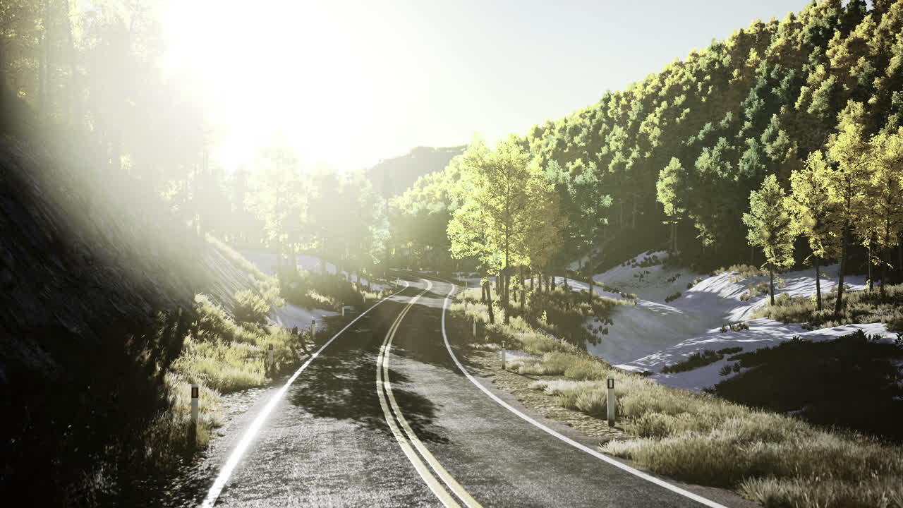 Serene mountain road winding through a vibrant autumn landscape at dawn