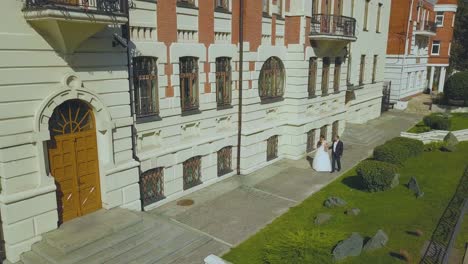 just married couple walks past restored building upper view