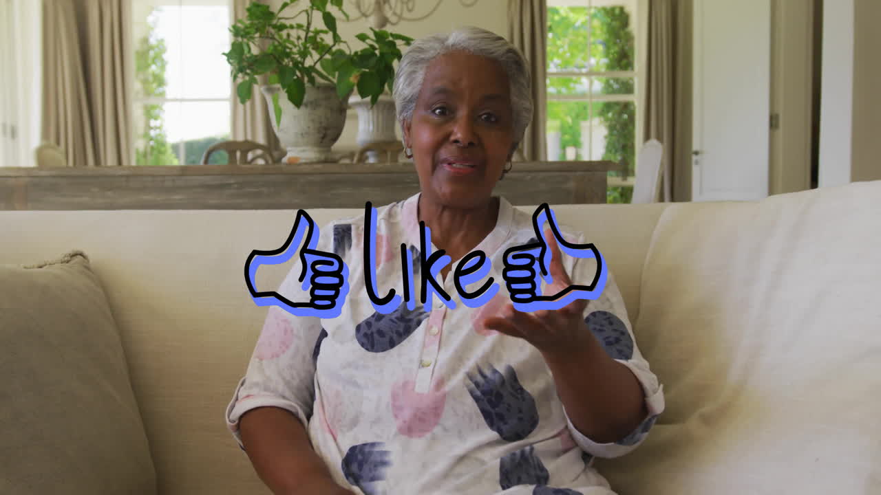 Senior woman sitting on sofa, showing social media engagement with animated thumbs?up graphics