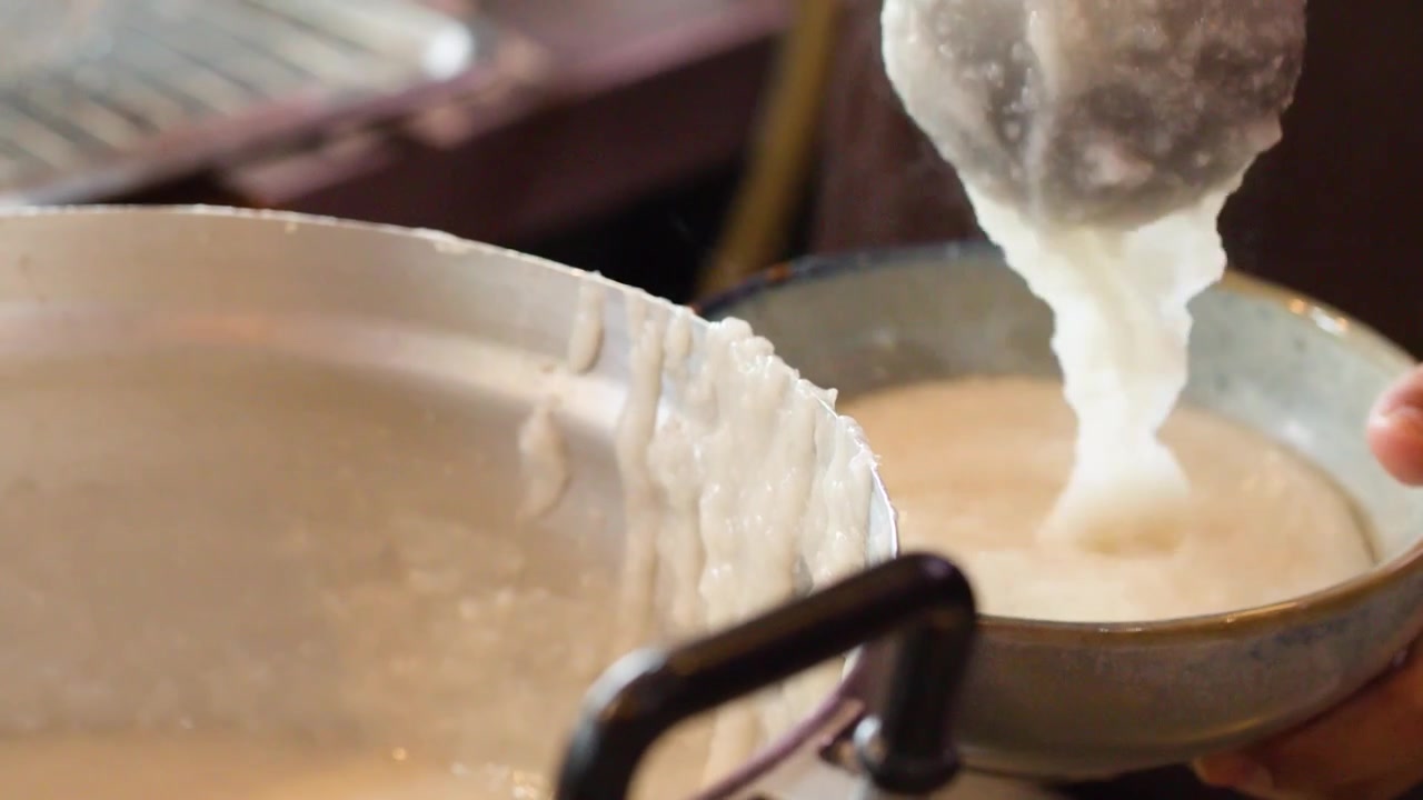 Chef Serving Hot Rice Porridge into a Bowl