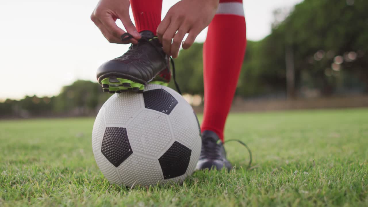 video de un jugador de fútbol biracial con la pelota atada a los cordones