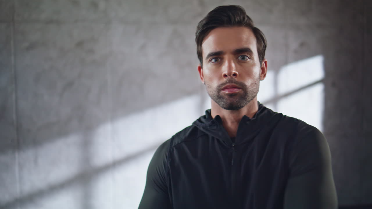 Fitness guy warming up stretching neck indoor portrait. Man preparing training