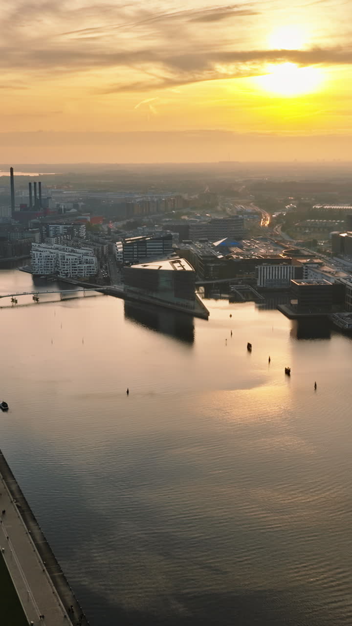 Aerial drone view of the Islands Brygge harbourfront area in central Copenhagen, Denmark at sunset. Vertical
