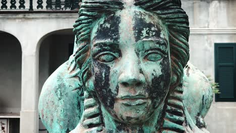 macro shot of the face of an old winged woman statue - close up