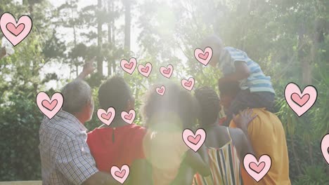 Animation-of-hearts-over-happy-african-american-multi-generation-family-in-garden