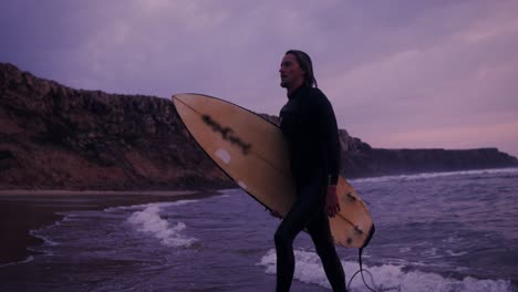 man surfs at sunset