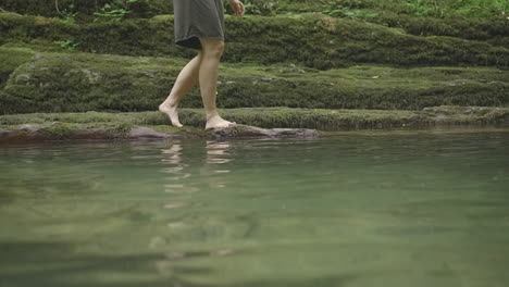 person walking in a shallow stream