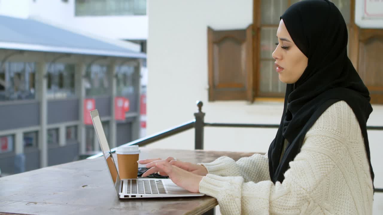 Woman in hijab using laptop 4k