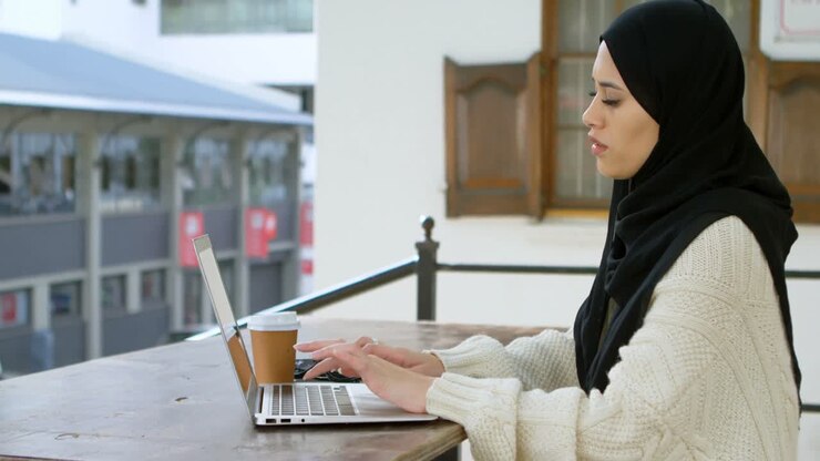 Woman in hijab using laptop 4k
