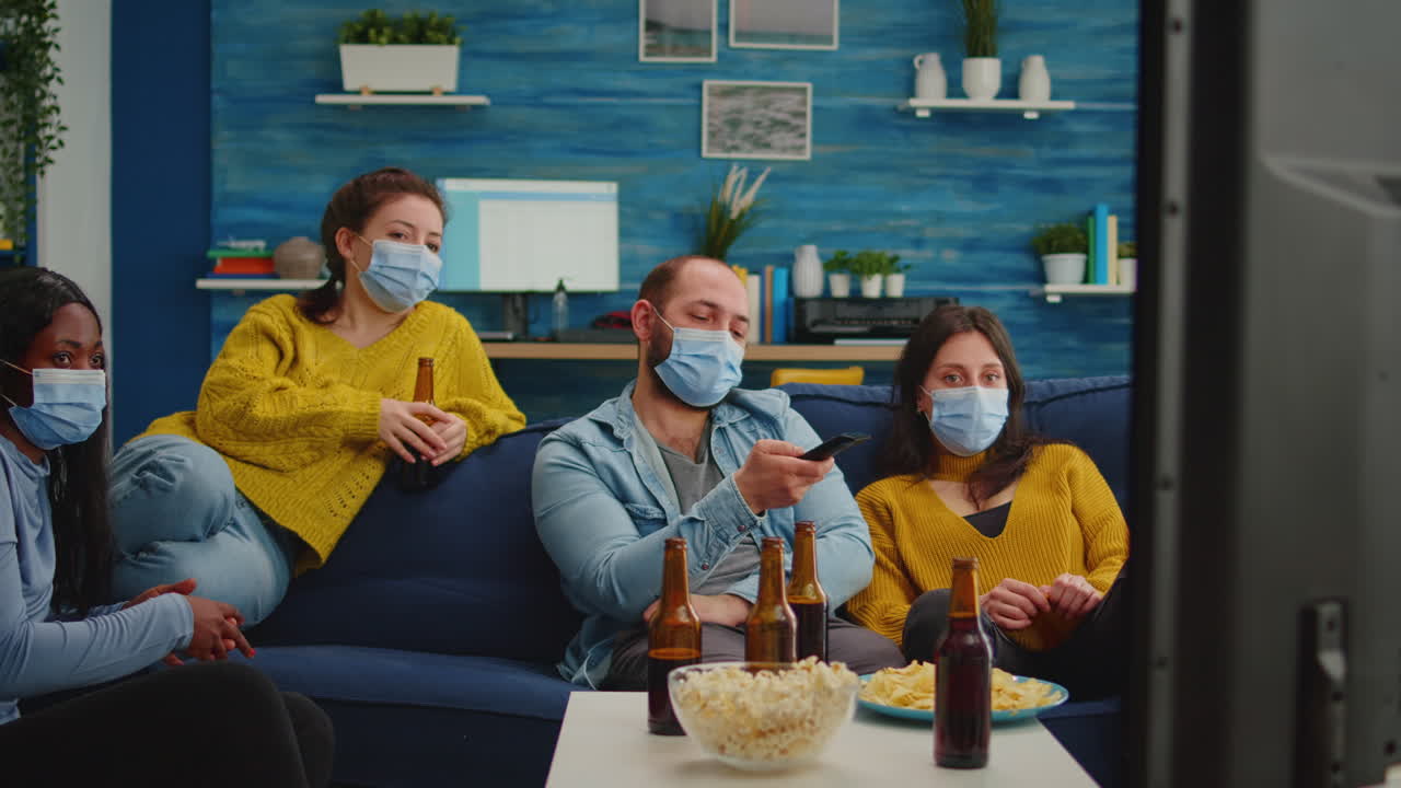 Diverse people relaxing together watching tv holding remote control