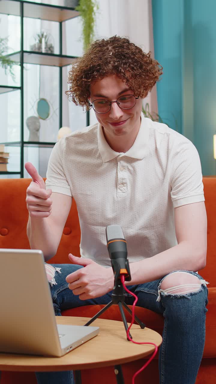 Ein glücklicher Blogger, der Podcast auf der Couch aufnimmt, einen Workshop veranstaltet und zu Hause bei einem Mikrofon-Webinar spricht