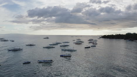 Cinematic-drone-shot-close-to-the-water-surface-flying-towards-the-sky-revealing-boats-and-islands-in-the-Philippines,-Aerial,-Asia