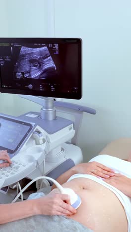 expecting mother undergoing ultrasound examination with medical equipment in a clinical setting