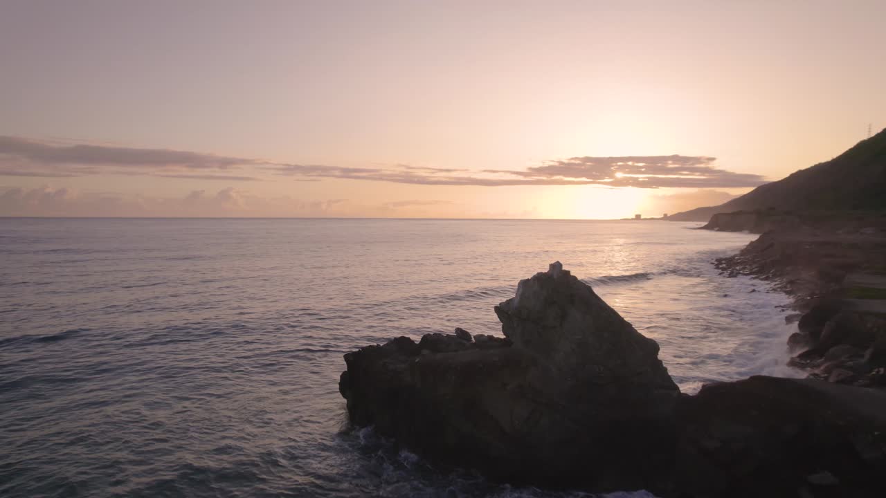 Drone flying over the rocky Caribbean coastline during sunrise