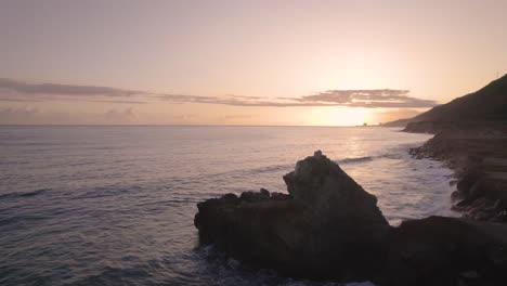 drone flying over the rocky caribbean coastline during sunrise