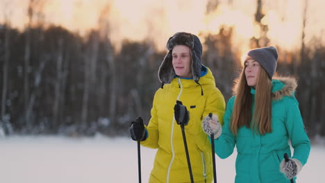 Im-Winterwald-Fahren-Bei-Sonnenuntergang-Ein-Mann-Und-Eine-Frau-Ski-Und-Schauen-Sich-In-Zeitlupe-Die-Schönheit-Der-Natur-Und-Der-Sehenswürdigkeiten-An.