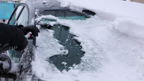 Frauenhände-Reinigen-Die-Windschutzscheibe-Von-Schnee-Und-Eis---Nahaufnahme