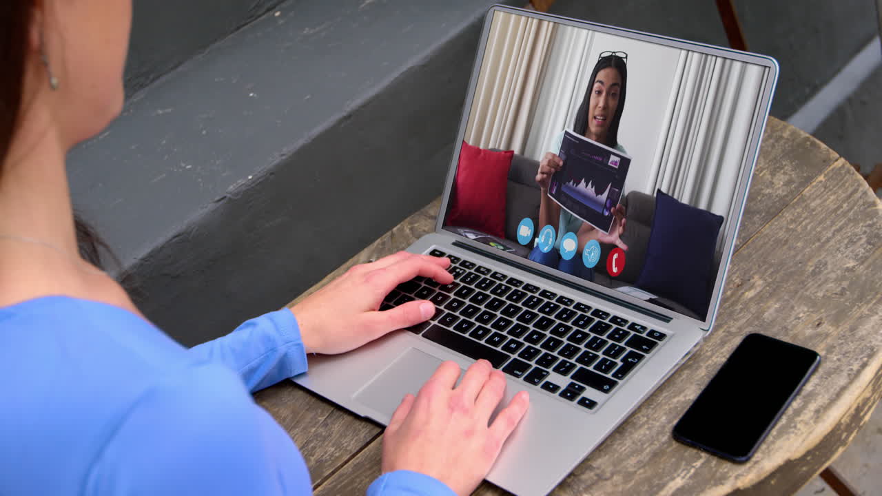 Caucasian businesswoman sitting at desk using laptop having video call with female colleague