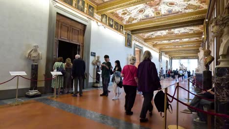 people exploring the uffizi gallery's ornate hallway