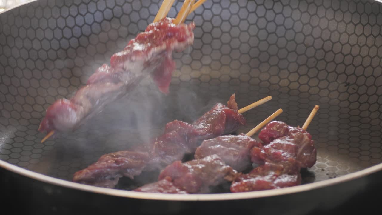 Pork meat skewer on fire, Mutton barbecue close-up. Fried meat for kebab. Cooking grilled meat beef chicken lamb BBQ . Kebab on grill. Chinese street local market with traditional food. Asian fast food.