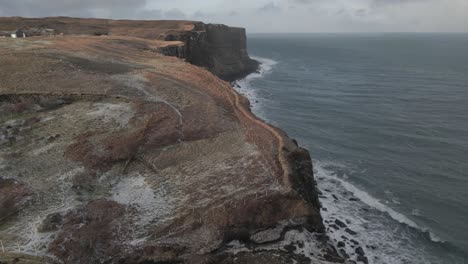 Falda-Escocesa-Y-El-Mar-Circundante-En-La-Isla-De-Skye,-Centrándose-En-Los-Espectaculares-Acantilados-Y-La-Costa,-Vista-Aérea