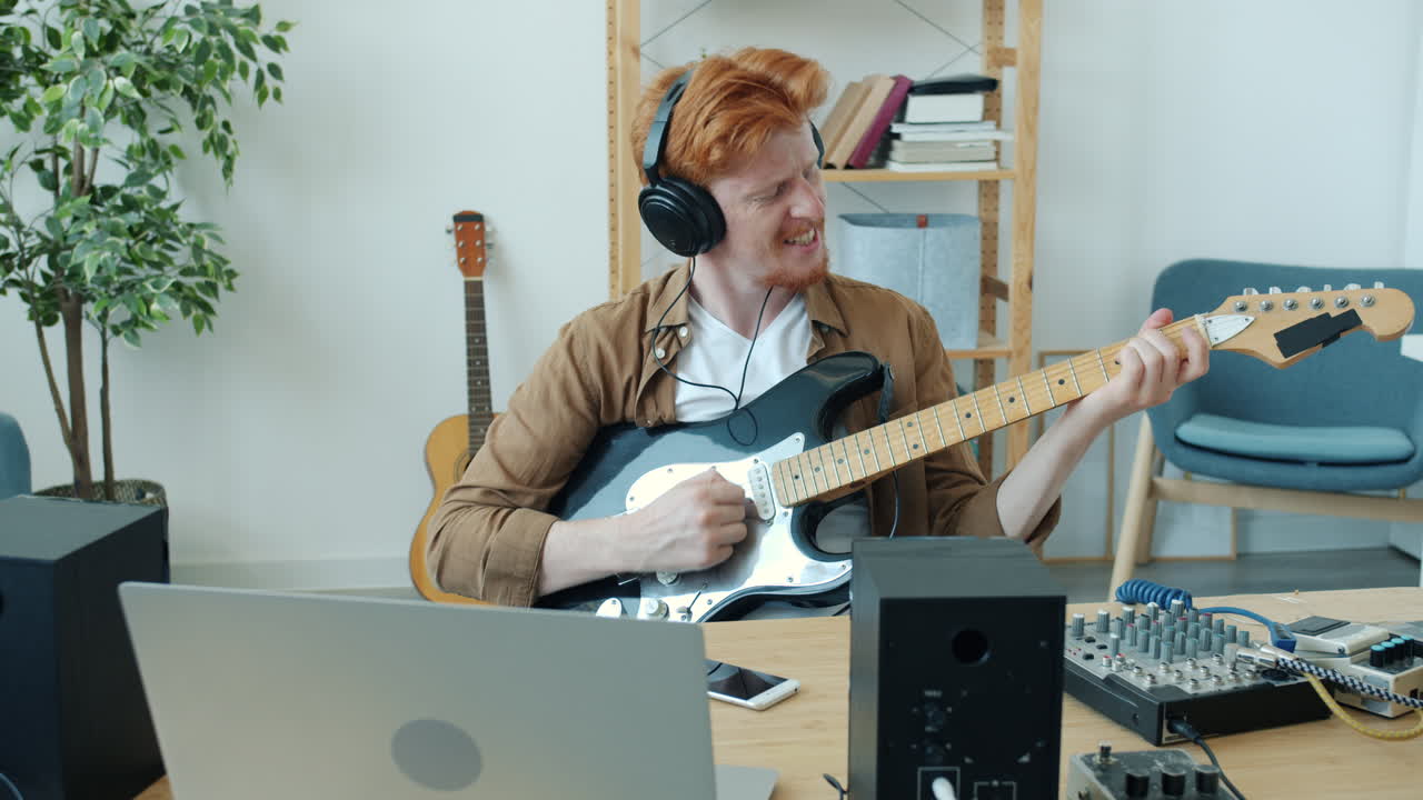 hombre tocando la guitarra eléctrica en el estudio casero