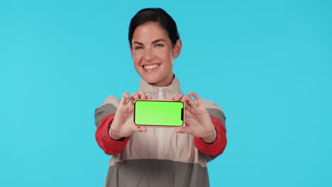 mujer sosteniendo un teléfono inteligente con pantalla verde
