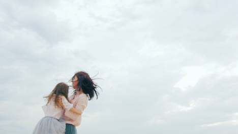 young mother plays with daughter on the beach 02