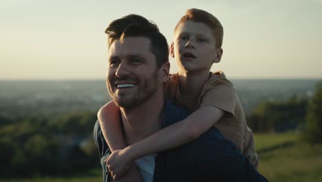 Dad-with-little-boy-walking-at-the-meadow-in-summer-day.