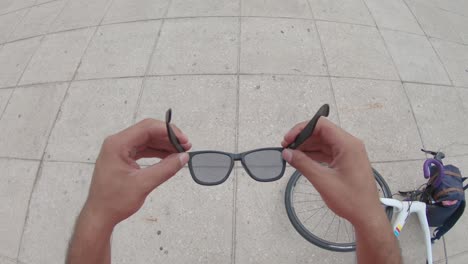 a young man's hands placing sunglasses in his face slowly, pov