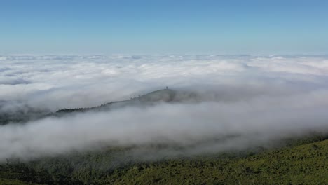 vista aérea del paisaje prístino de la isla de madeira, portugal, nubes bajas sobre la selva tropical y colinas verdes en un día soleado, disparo de drones