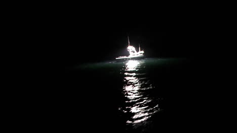 a fishcutter works at night in the open seas